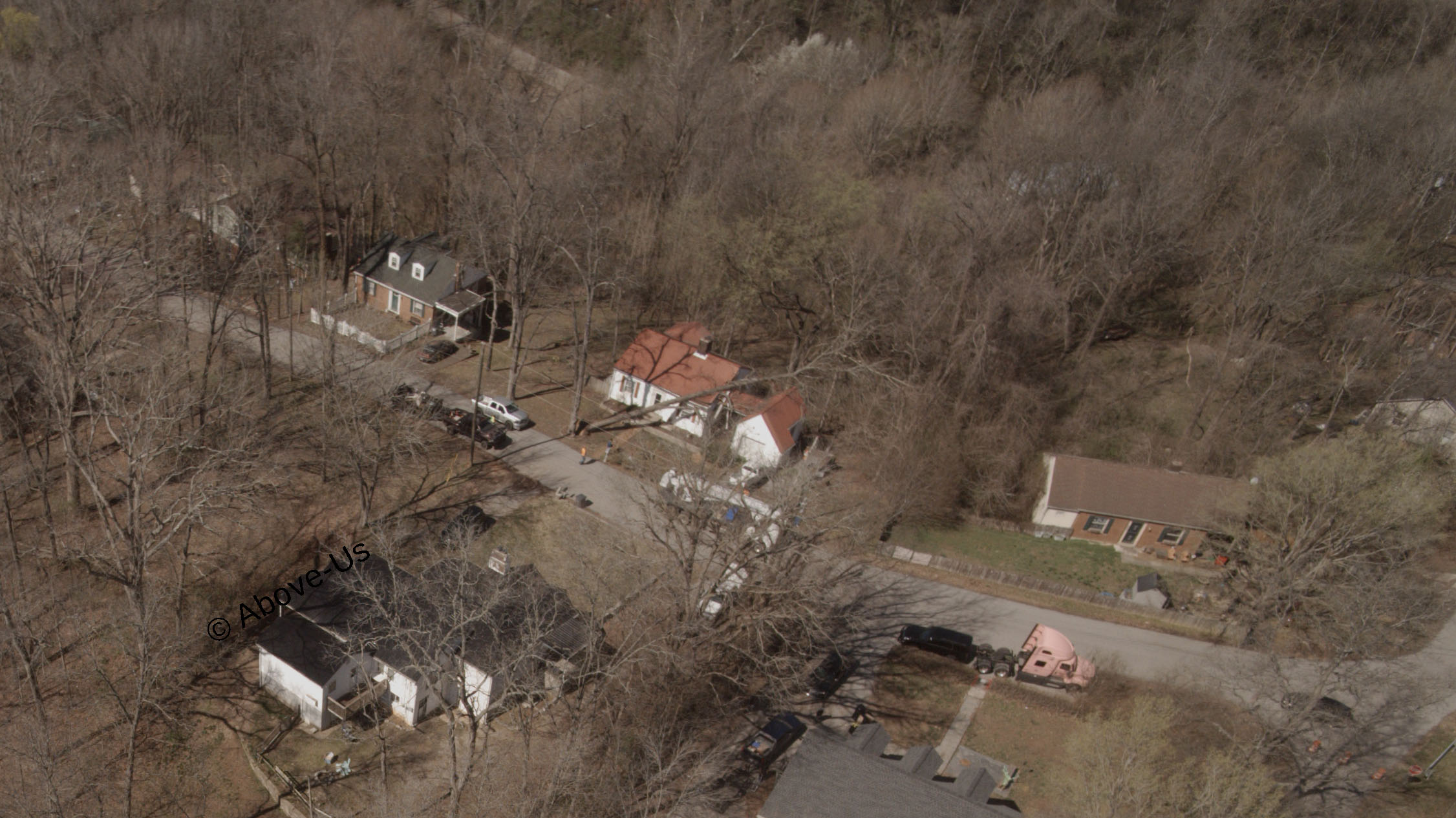 An aerial picture of a fallen tree resting on a house